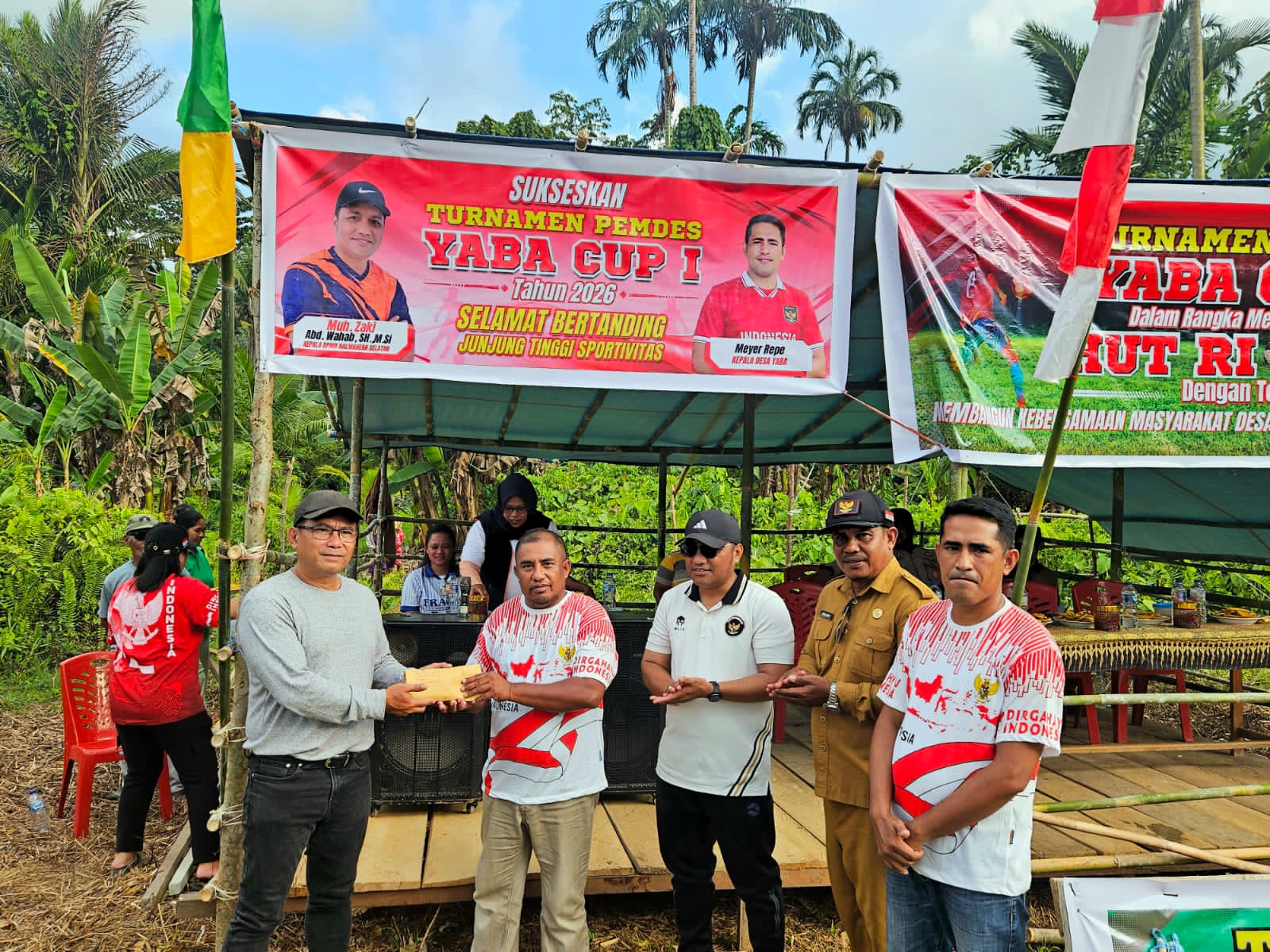 Manajemen PT IMM menyerahkan bantuan uang tunai kepada panitia pelaksana turnamen di Desa Yaba.