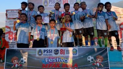Senyum penuh kebanggaan, pemain SSB Tomara Am mengangkat trofi juara setelah sukses memenangkan Festival Sepak Bola Anak Merdeka U-10 di Lapangan GOR Desa Tuokona